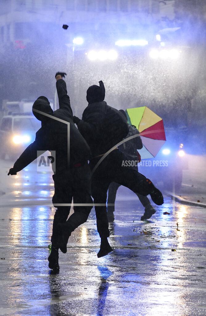 Jan Woitas Left-wing demonstrators throw stones at a water cannon during riots in Leipzig, Germany, Saturday, Sept. 18, 2021. The campaign alliance "We are all Linx" had mobilized nationwide for the demonstration. (Jan Woitas/dpa via AP)