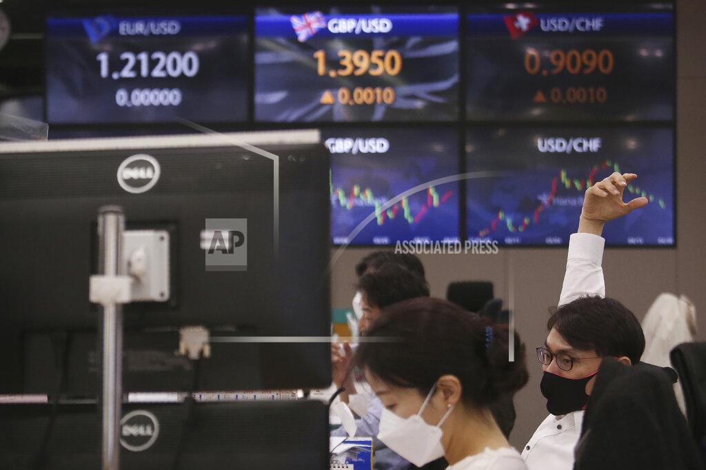 Ahn Young-Joon A currency trader stretches at the foreign exchange dealing room of the KEB Hana Bank headquarters in Seoul, South Korea, Friday, April 30, 2021. Asian shares were mostly lower Friday amid uncertainty about the prospects for a gradual global economic recovery from the coronavirus pandemic. (AP Photo/Ahn Young-joon)