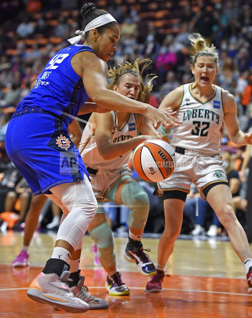 Sean D. Elliot Connecticut Sun center Brionna Jones, left, and New York Liberty's Sabrina Ionescu, center, and Sami Whitcomb (32) vie for the ball during the first half of a WNBA basketball game Wednesday, Sept. 15, 2021, in Uncasville, Conn. (Sean D. Elliot/The Day via AP)