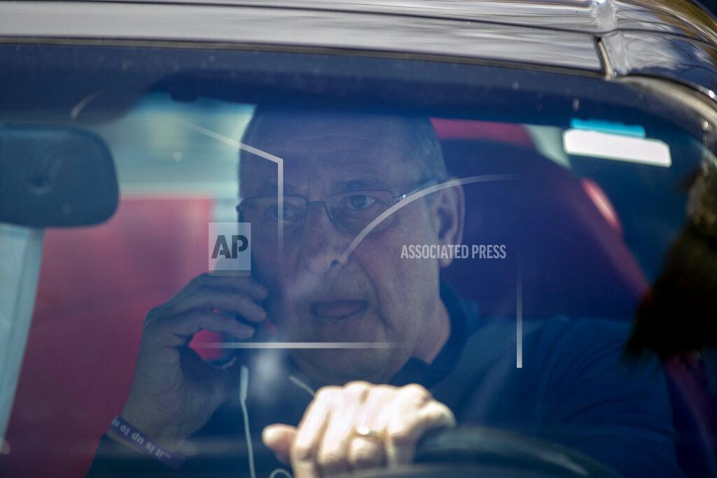Robert F. Bukaty Former Gov. Paul LePage, sitting in a Lexus SC 430, uses his cell phone to address protesters rallying against the executive orders by Gov. Janet Mills to keep some Maine businesses closed to help prevent the spread of coronavirus, Saturday, May 16, 2020, in Augusta, Maine. His call was broadcast over speakers set up at the nearby rally. LePage, now a resident of Florida, stayed in his car parked near the rally. A speaker at the event said the former governor was quarantining. (AP Photo/Robert F. Bukaty)