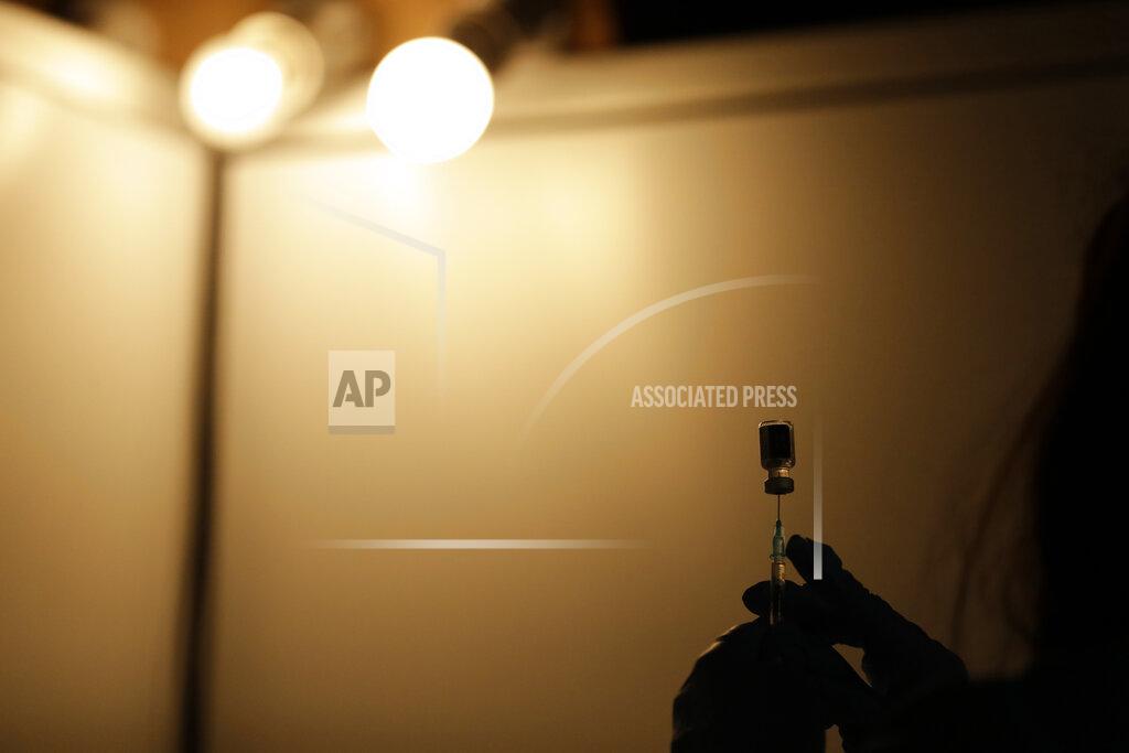 A volunteer vaccinator prepares to administer a dose of the Pfizer coronavirus vaccine at a vaccine centre in the Swaminarayan School in Neasden, north London, Saturday, May 1, 2021. (AP Photo/Matt Dunham)