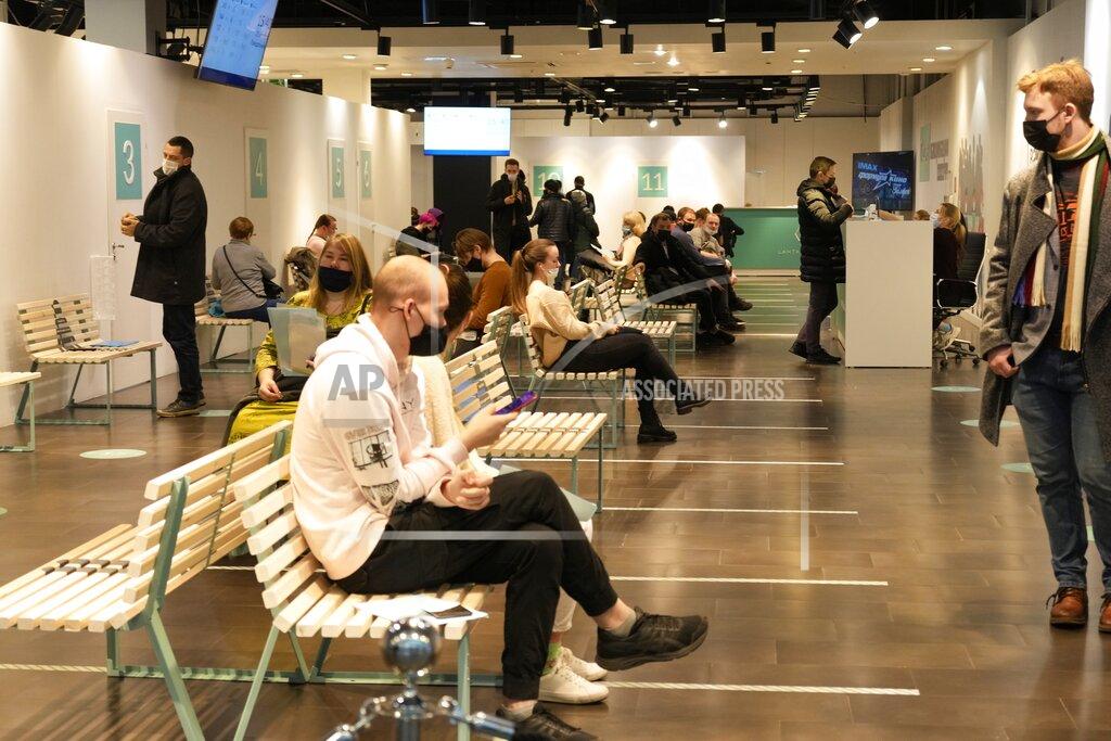 Dmitri Lovetsky People wait to gets a shot of the Sputnik vaccine at a vaccination center at a shopping mall in St. Petersburg, Russia, Monday, Oct. 25, 2021. Russia has reported another daily record of confirmed coronavirus cases as a surge in infections has prompted the Kremlin to tell most people to stay away from work starting later this week. Only about 45 million Russians — roughly a third of the country's nearly 146 million people — are fully vaccinated. (AP Photo/Dmitri Lovetsky)