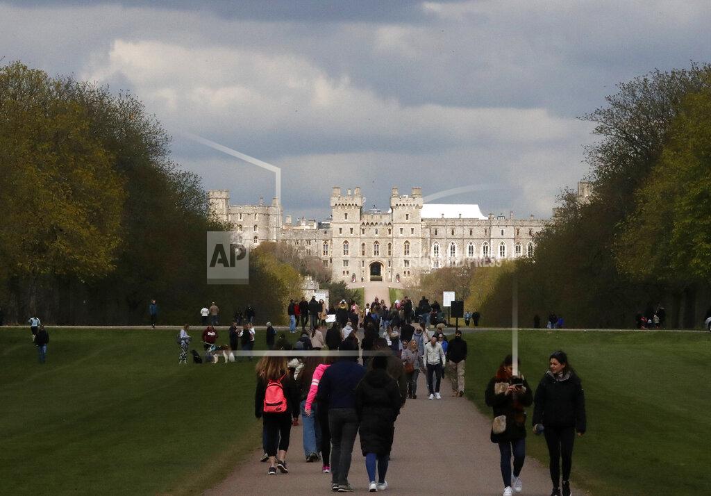 Frank Augstein People walk on the long walk towards Windsor Castle, Windsor, England, Sunday, April 11, 2021, after the announcement of the death of Britain's Prince Philip on Friday. Britain's Prince Philip, the irascible and tough-minded husband of Queen Elizabeth II who spent more than seven decades supporting his wife in a role that mostly defined his life, died on Friday. (AP Photo/Frank Augstein)