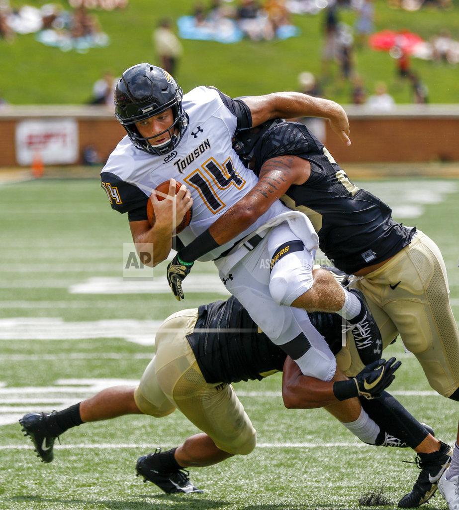 Nell Redmond Towson quarterback Tom Flacco (14) is tackled by Wake Forest linebackers Demetrius Kemp, left, and Justin Strnad in the first half of a NCAA college football game in Winston-Salem, N.C., Saturday, Sept. 8, 2018. (AP Photo/Nell Redmond)
