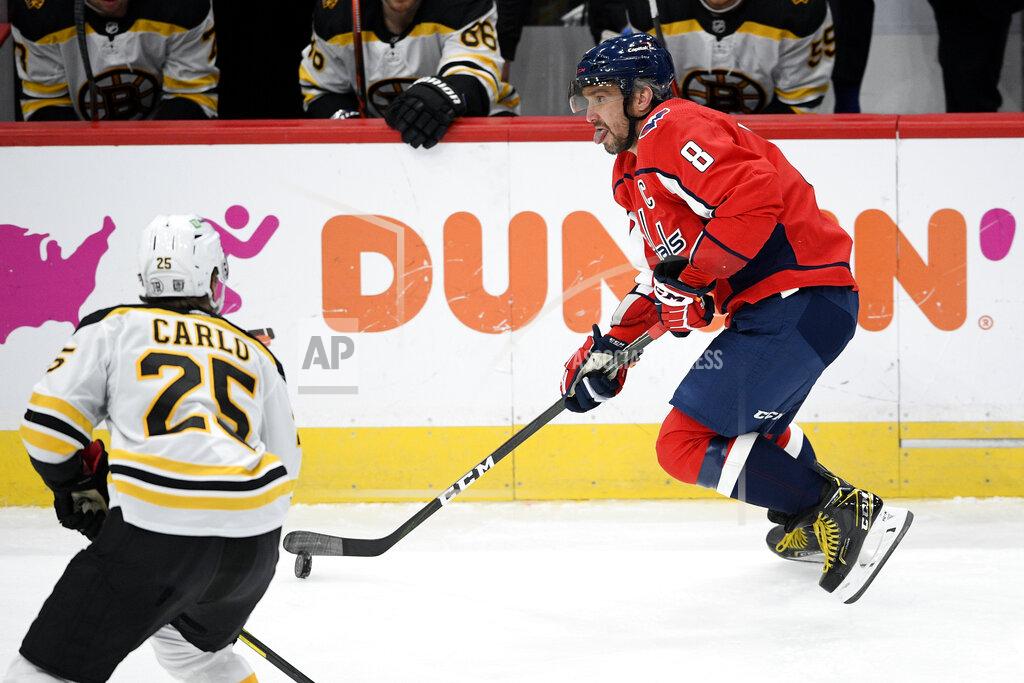 Nick Wass Washington Capitals left wing Alex Ovechkin (8), of Russia, skates with the puck next to Boston Bruins defenseman Brandon Carlo (25) during the first period of an NHL hockey game, Saturday, Jan. 30, 2021, in Washington. (AP Photo/Nick Wass)