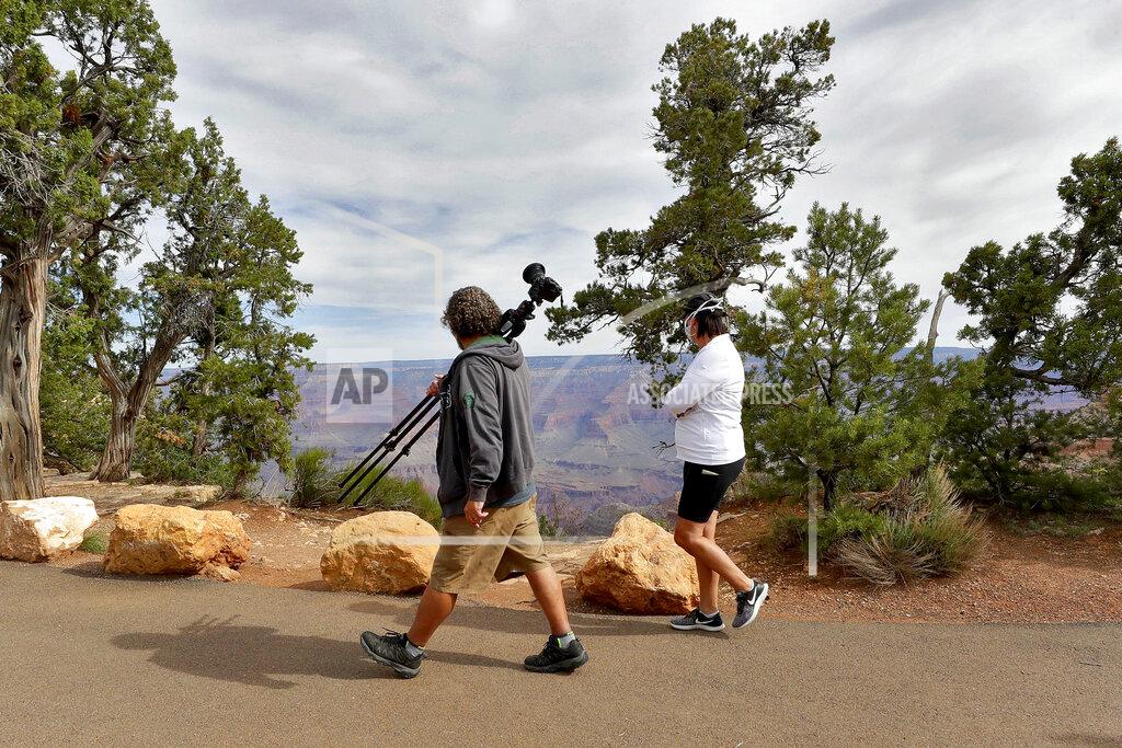 Matt York Visitors gather at the Grand Canyon Friday, May 15, 2020, in Grand Canyon, Ariz. Tourists are once again roaming portions of Grand Canyon National Park when it partially reopened Friday morning, despite objections that the action could exacerbate the coronavirus pandemic.(AP Photo/Matt York)