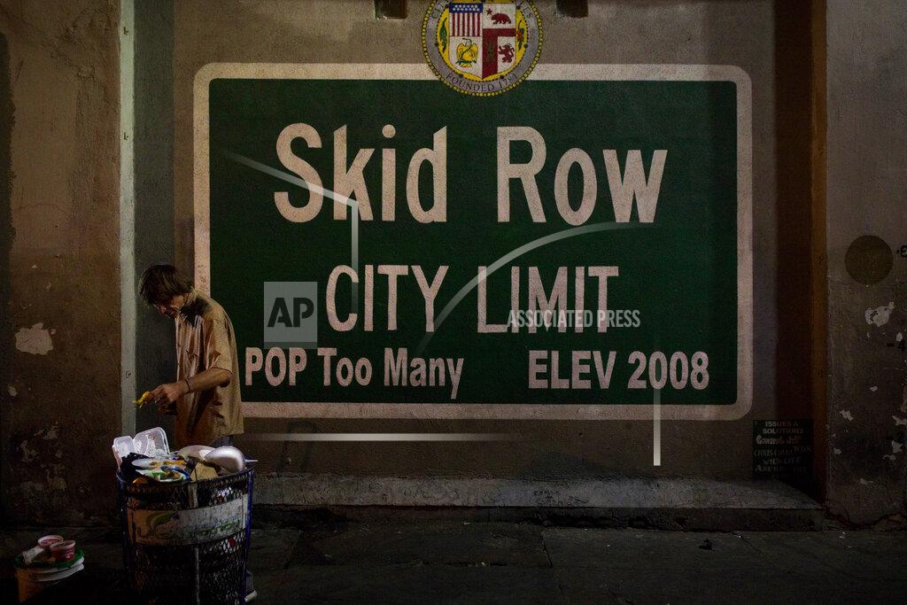 Jae C. Hong FILE - In this Oct. 28, 2017, file photo, a homeless man takes food from a trash can in Los Angeles' Skid Row area, home to the nation's largest concentration of homeless people in Los Angeles. A federal judge overseeing a sweeping lawsuit about homelessness in Los Angeles on Tuesday, April 20, 2021, ordered the city and county to find shelter for all unhoused residents of Skid Row within 180 days and audit any spending related to the out-of-control crisis of people living on the streets. (AP Photo/Jae C. Hong, File)