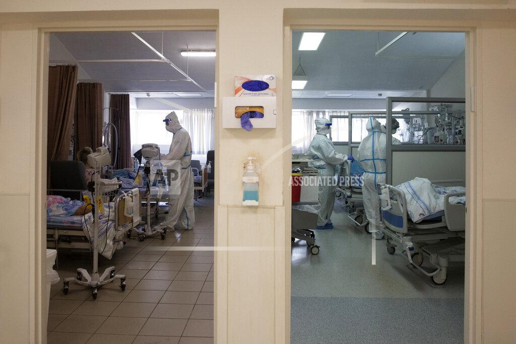 Maya Alleruzzo FILE - In this Aug. 26, 2021, file, photo, medical professionals treat patients in the coronavirus ward at Barzilai Medical Center in Ashkelon, Israel. Israeli health officials say the booster shot, which has already been delivered to about a third of the population, is helping to suppress the country’s latest wave of COVID-19 infections. (AP Photo/Maya Alleruzzo, File)