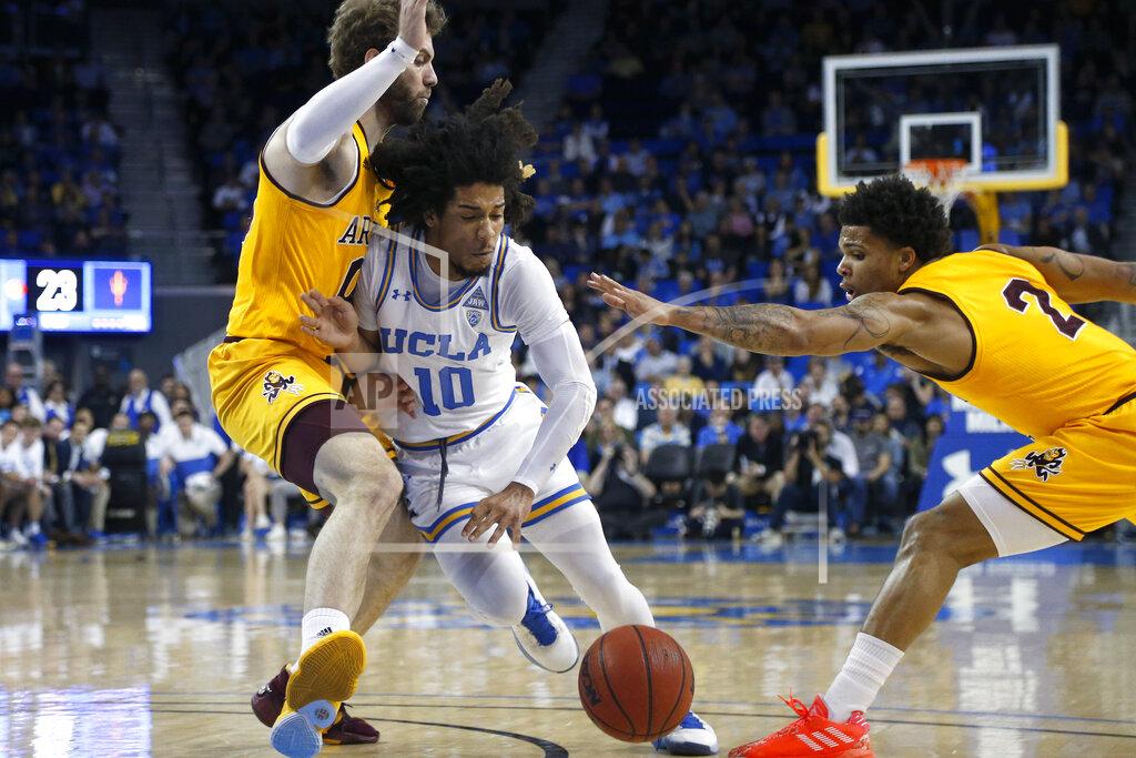 Ringo H.w. Chiu UCLA guard Tyger Campbell (10) drives between Arizona State forward Mickey Mitchell, left, and guard Rob Edwards (2) during an NCAA college basketball game Thursday, Feb. 27, 2020, in Los Angeles. (AP Photo/Ringo H.W. Chiu)