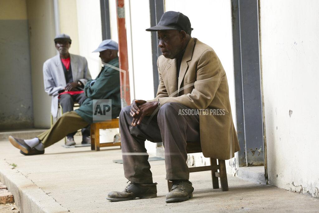 Tsvangirayi Mukwazhi Elderly men sit outside their rooms at the Society for the Destitute Aged care home in Harare's Highfield township, Zimbabwe, Thursday June 24, 2021. The economic ravages of COVID-19 are forcing some families in Zimbabwe to abandon the age old tradition of taking care of the elderly. Zimbabwe's care homes have experienced a 60% increase in admissions since the outbreak of the pandemic in March last year. (AP Photo/Tsvangirayi Mukwazhi)