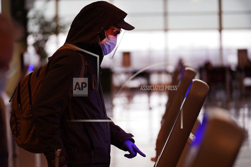 Charles Rex Arbogast FILE - In this Nov. 24, 2020 file photo, an air traveler checks in wearing a protective mask, face shield and protective gloves, for his flight on Southwest Airlines at Midway Airport in Chicago. As few people traveled, the airline industry needed billions of dollars in aid from the government and is still threatening to lay off workers.(AP Photo/Charles Rex Arbogast)