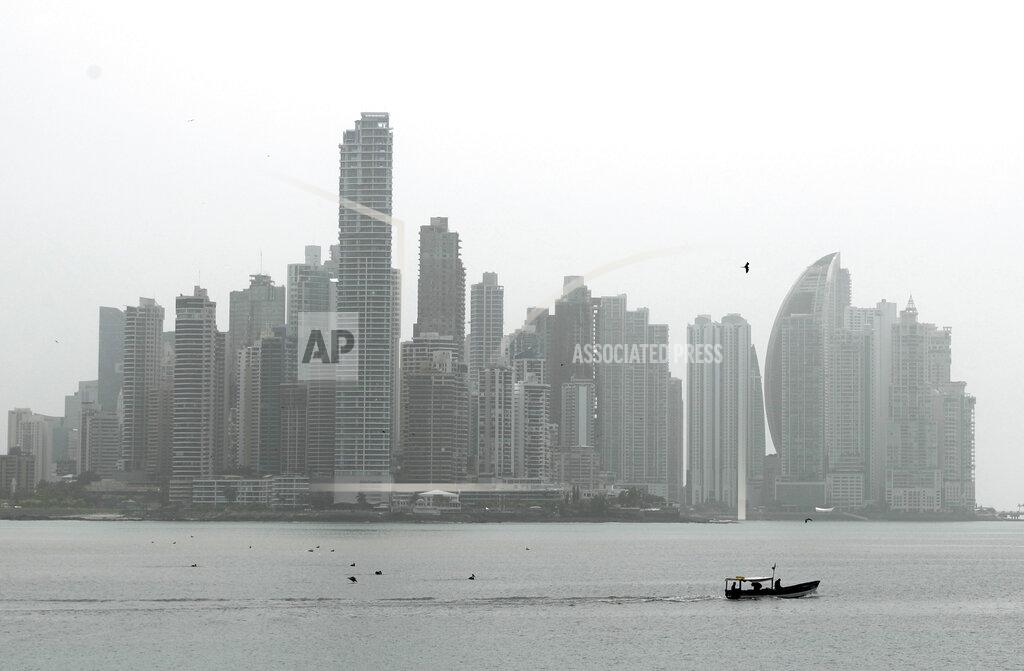 A fishing boat cruises past backdropped by the Panama City skyline, Thursday, June 25, 2020. New COVID-19 infections have been surging in Panama since the country began relaxing its strict quarantine in an effort to reactivate its economy. After holding more or less steady for two months the number of infections has tripled. (AP Photo/Arnulfo Franco)