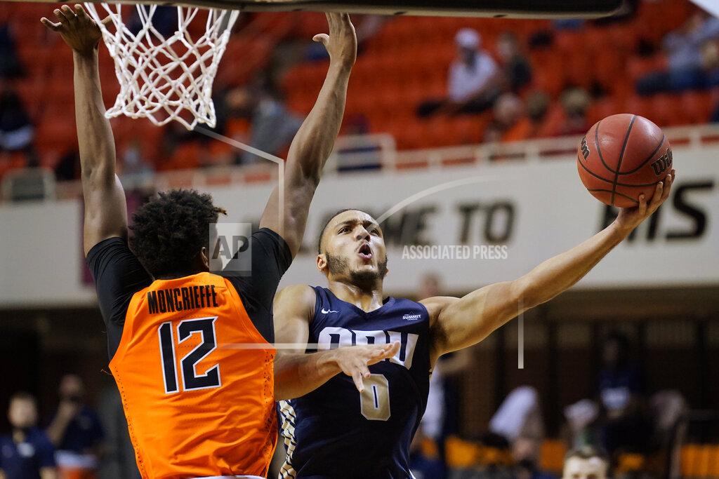 Sue Ogrocki Oral Roberts forward Kevin Obanor (0) shoots as Oklahoma State forward Matthew-Alexander Moncrieffe (12) defends during the first half of an NCAA college basketball game Tuesday, Dec. 8, 2020, in Stillwater, Okla. (AP Photo/Sue Ogrocki)