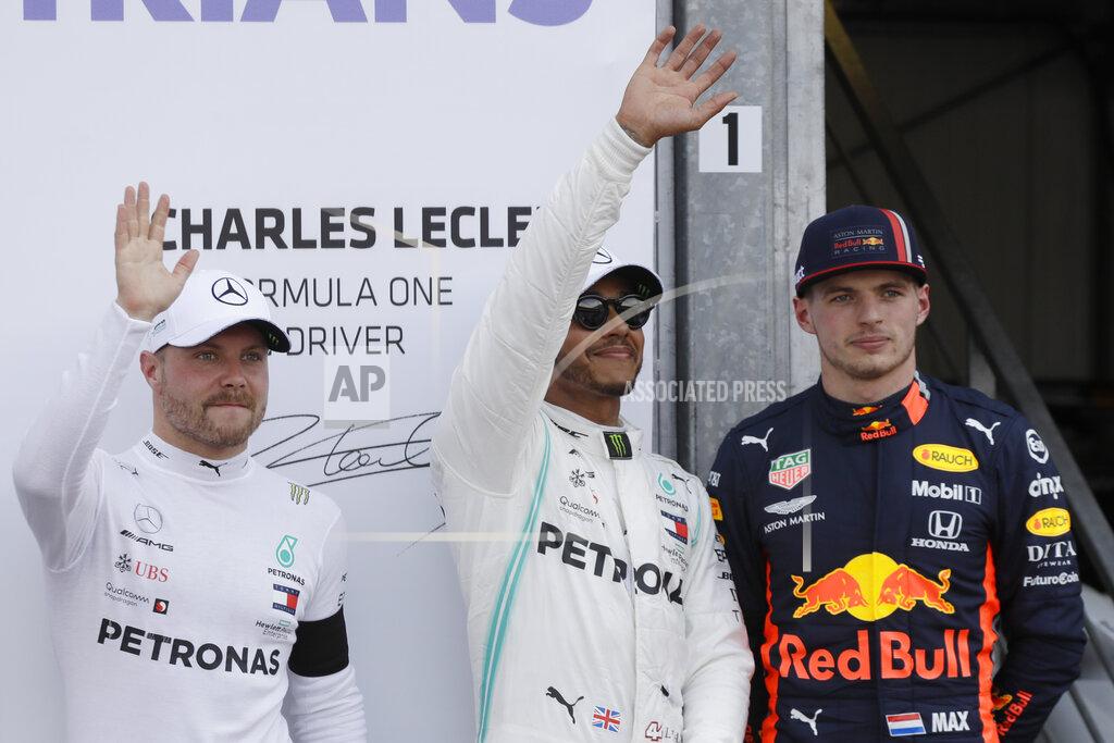 Luca Bruno Mercedes driver Lewis Hamilton of Britain, center, who earned pole position, Red Bull driver Max Verstappen of the Netherland's, right, who came in third and Mercedes driver Valtteri Bottas of Finland, left, who earned the second best time, posing for photos after the qualifying session at the Monaco racetrack, in Monaco, Saturday, May 25, 2019. The Formula one race will be held on Sunday. (AP Photo/Luca Bruno)