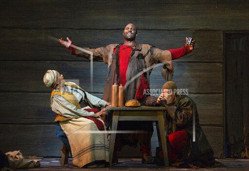 This image released by The Metropolitan Opera shows bass-baritone Ryan Speedo Green as Varlaam, center, with Tichina Vaughn as the Hostess of the Inn, left, and Brenton Ryan as Missail. in a scene from Mussorgsky's "Boris Godunov" in rehearsal last September in New York. (Marty Soh/The Metropolitan Opera via AP)