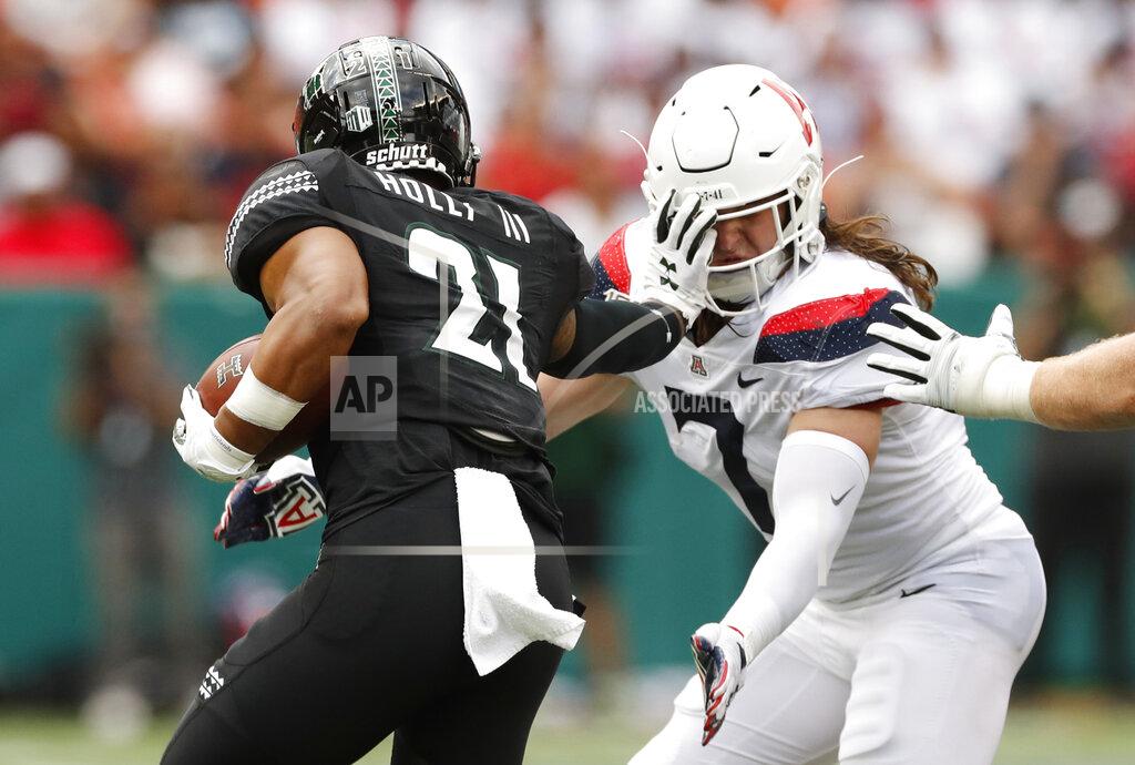 Marco Garcia Hawaii running back Fred Holly III (21) stiff -arms Arizona linebacker Colin Schooler (7) during the first quarter of an NCAA college football game Saturday, Aug. 24, 2019, in Honolulu. (AP Photo/Marco Garcia)