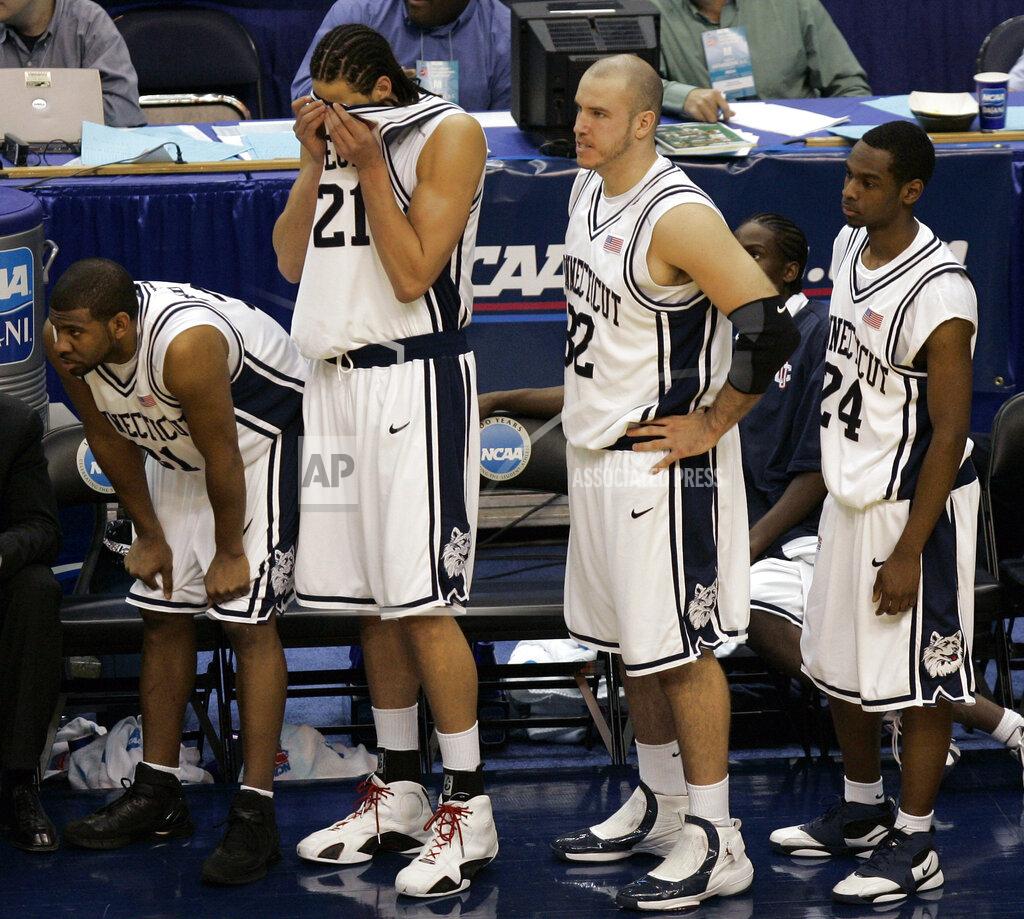 Susan Walsh FILE - In this March 26, 2006, file photo, Connecticut players Rashad Anderson, left, Josh Boone (21), Ed Nelson (32), and Craig Austrie (24), watch the game from the sidelines during a loss to George Mason in the fourth round of the NCAA basketball tournament in Washington. George Mason beat Michigan State, North Carolina and Wichita State before taking down No. 1 seed Connecticut and its roster full of NBA talent 86-84 in overtime. They lost 73-58 to eventual national champion Florida in the semifinals. (AP Photo/Susan Walsh, File)