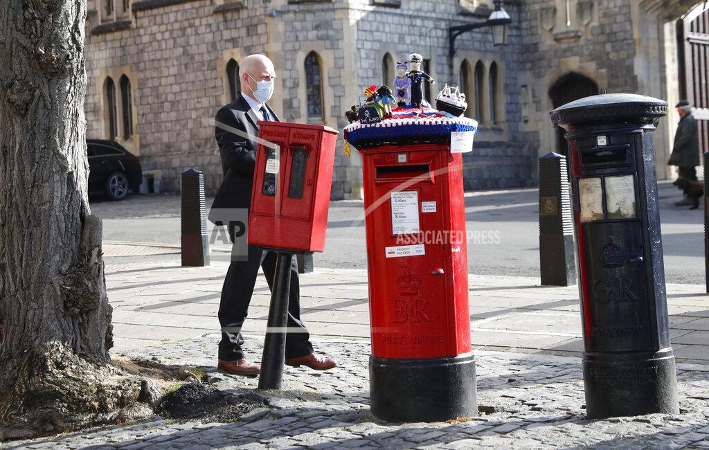 Alastair Grant A knitted top cover for a post box depicting Britain's Queen Elizabeth II and her husband Prince Philip is exposed in Windsor, England, Friday, April 16, 2021. Prince Philip husband of Britain's Queen Elizabeth II died April 9, aged 99, his funeral will take place Saturday at Windsor Castle in St George's Chapel. The knitted top show some of Prince Philips favourite things, the Royal Yacht Britannia, right, the Duke of Edinburgh award scheme for young people and his hobby of carriage driving . (AP Photo/Alastair Grant)