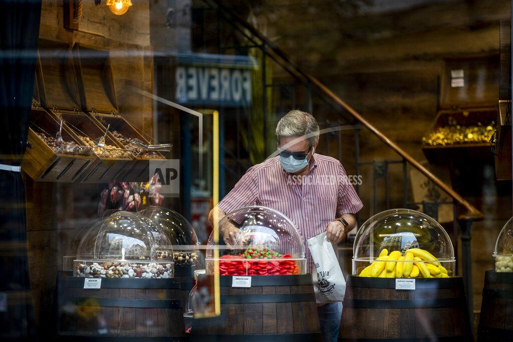 Manu Fernandez A man wearing a face mask to prevent the spread of coronavirus buys sweets in downtown Madrid, Spain, Wednesday, Sept. 16, 2020. The Spanish capital will introduce selective lockdowns in urban areas where the coronavirus is spreading faster, regional health authorities announced on Tuesday. (AP Photo/Manu Fernandez)