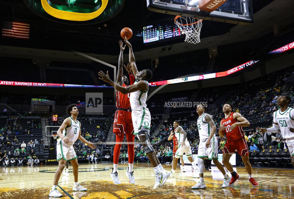 Thomas Boyd Oregon center N'Faly Dante (1) blocks the shot of Utah center Lahat Thioune (0) during the second half of an NCAA college basketball game in Eugene, Ore., Saturday, Jan. 1, 2022. (AP Photo/Thomas Boyd)