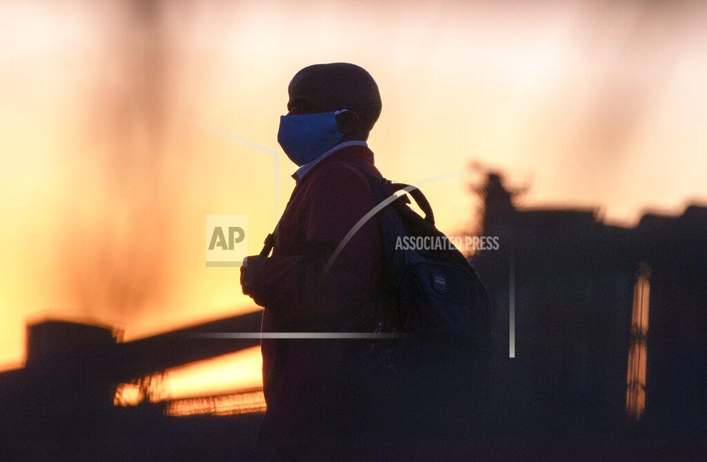Themba Hadebe A man wearing protective masks to help curb the spread of the coronavirus walks back home from work in Germiston, near Johannesburg, South Africa, Thursday, Aug. 13, 2020. An Africa-wide study of antibodies to the coronavirus has begun, while evidence from a smaller study indicates that many more people have been infected than official numbers show, the Africa Centers for Disease Control and Prevention said Thursday. (AP Photo/Themba Hadebe)