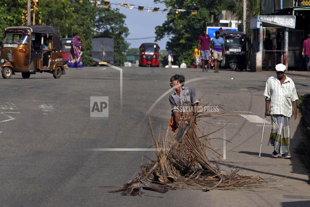 Eranga Jayawardena A man pulls fallen coconut leaves to be used as firewood amid shortage of cooking gas along a usually congested road in Colombo, Sri Lanka, Thursday, June 23, 2022. Sri Lanka's prime minister says the island nation's debt-laden economy has "collapsed" as it runs out of money to pay for food and fuel. (AP Photo/Eranga Jayawardena)