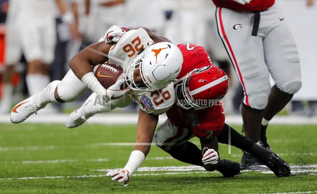 Gerald Herbert Texas running back Keaontay Ingram (26) is brought down by Georgia defensive back Richard LeCounte (2) during the first half of the Sugar Bowl NCAA college football game in New Orleans, Tuesday, Jan. 1, 2019. (AP Photo/Gerald Herbert)