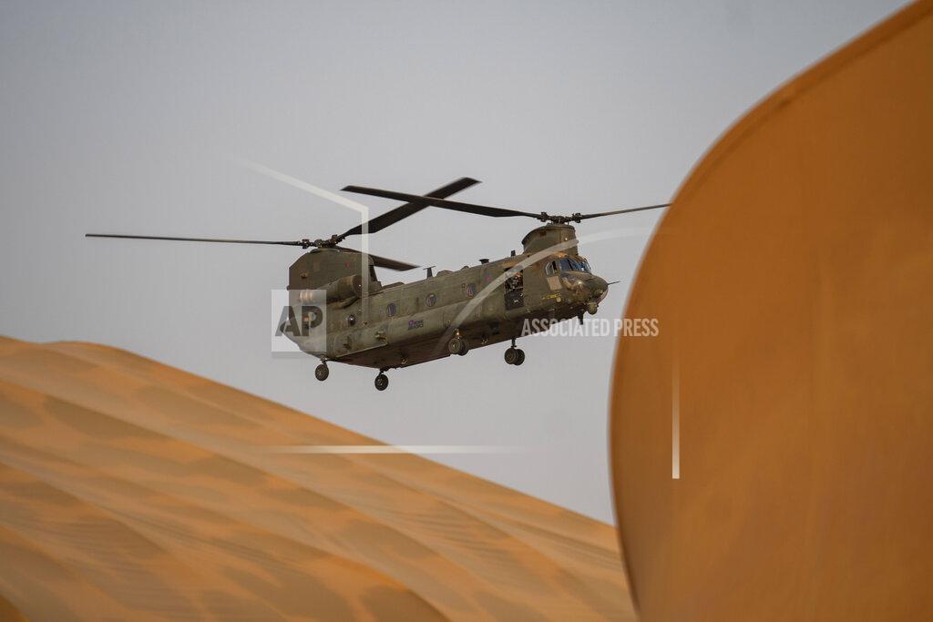 Uncredited A British Royal Air Force transport helicopter hoovers over the tarmac of Barkhane Operation base in Gao, Mali Monday June 7, 2021. After France suspended joint military operations with Malian forces after the junta led by Col. Assimi Goita retook control of Mali's transitional government May 24 2021, French President Emmanuel Macron announced at a press conference Thursday June 10, 2021, that operation Barkhane would end and be replaced by support for local partners and counter terrorism. (AP Photo/Jerome Delay)