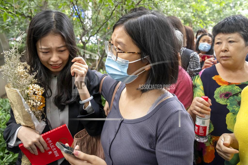 Mark Schiefelbein Zhou Xiaoxuan, left, a former intern at China's state broadcaster CCTV, reacts after being accosted by hostile bystanders outside a courthouse in Beijing, Tuesday, Sept. 14, 2021. Zhou became the face of the country's MeToo movement after going public with accusations against a prominent CCTV host in 2018. Since then, even as the movement was shut down by authorities, Zhou has continued to speak out. (AP Photo/Mark Schiefelbein)