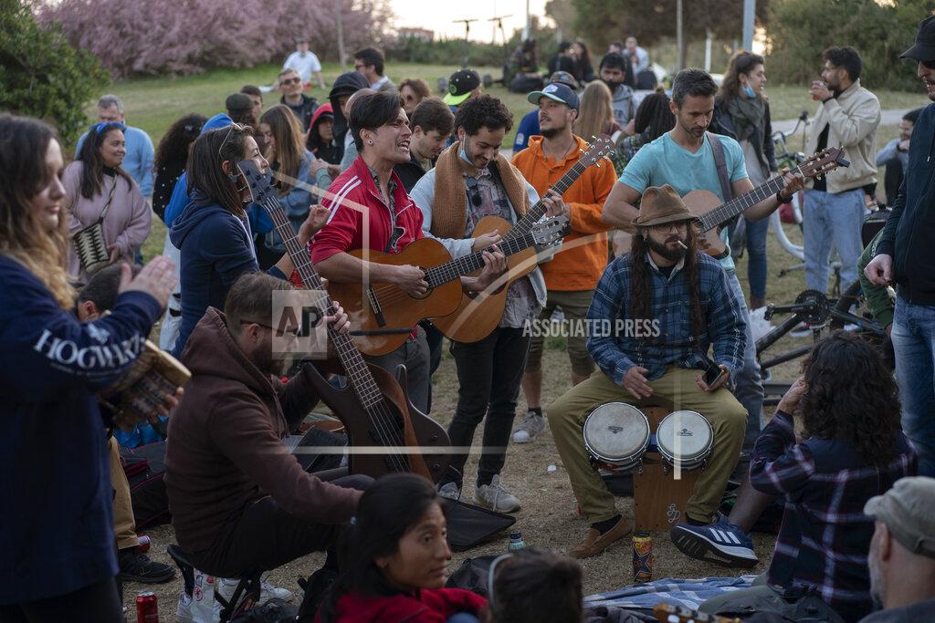Emilio Morenatti Local people play their instruments as they gather at a public park in Barcelona, Spain, Sunday, March 28, 2021. (AP Photo/Emilio Morenatti)