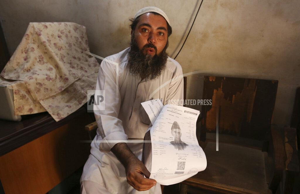 Fareed Khan Mullah Kaifat Ullah, a Muslim cleric who performs the Nikkah religious ceremony for Islamic marriages, explains required documents for marriage registration during an interview in Karachi, Pakistan, on Thursday, Nov. 12, 2020. While Ullah said he only marries girls 18 and above, he argued that “under Islamic law a girl’s wedding at the age of 14 or 15 is fine.” (AP Photo/Fareed Khan)