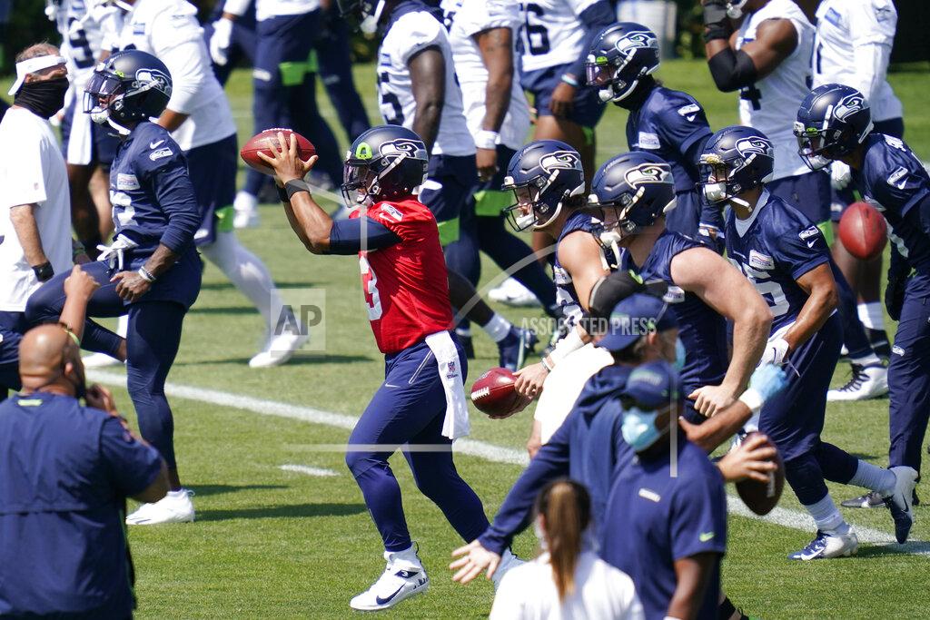Elaine Thompson Seattle Seahawks quarterback Russell Wilson (3) reaches for a ball as he runs through a drill with teammates Thursday, Aug. 13, 2020, in a practice during an NFL football training camp in Renton, Wash. (AP Photo/Elaine Thompson)