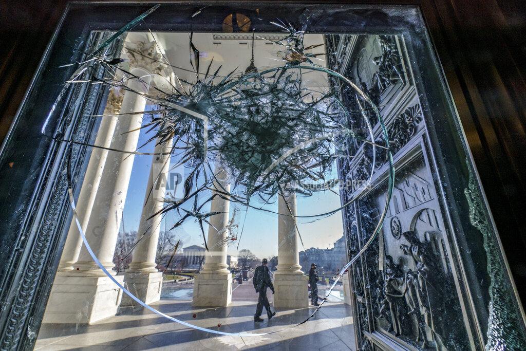 J. Scott Applewhite FILE - In this Jan. 12, 2021, file photo shattered glass from the attack on Congress by a violent pro-Trump mob is seen in doors leading to the Capitol Rotunda in Washington. Violent extremists motivated by political grievances and racial biases pose an “elevated threat” to the U.S. homeland, officials said Wednesday, March 17, in a unclassified intelligence report released more than two months after a violent mob of insurrectionists stormed the U.S. Capitol. (AP Photo/J. Scott Applewhite, File)