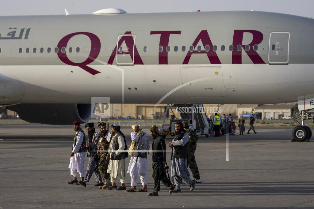 Bernat Armangue Taliban fighters walk past a Qatar Airways aircraft at the airport in Kabul, Afghanistan, Thursday, Sept. 9, 2021. Some 200 foreigners, including Americans, flew out of Afghanistan on an international commercial flight from Kabul airport on Thursday, the first such large-scale departure since U.S and foreign forces concluded their frantic withdrawal at the end of last month. (AP Photo/Bernat Armangue)