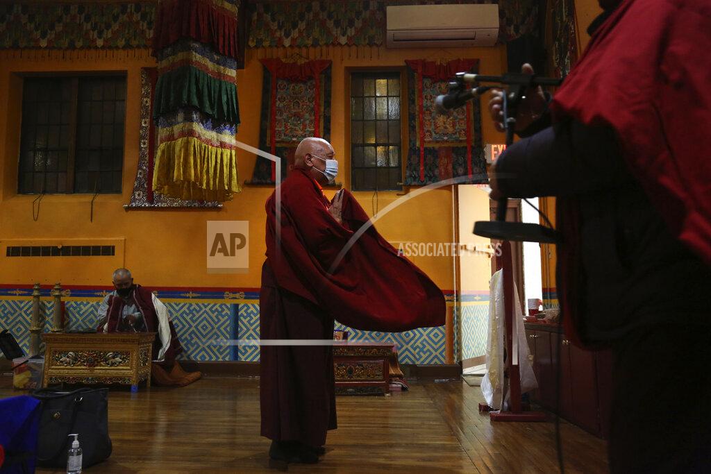 Lama Ngawang Yonten and other Buddhist members of the United Sherpa Association prepare for the Dakini Day practice, a group meditation that includes song and food and is celebrated on the 25th day of each lunar month, at their community temple in the Queens borough of New York on Friday, Jan. 8, 2021. (AP Photo/Jessie Wardarski)