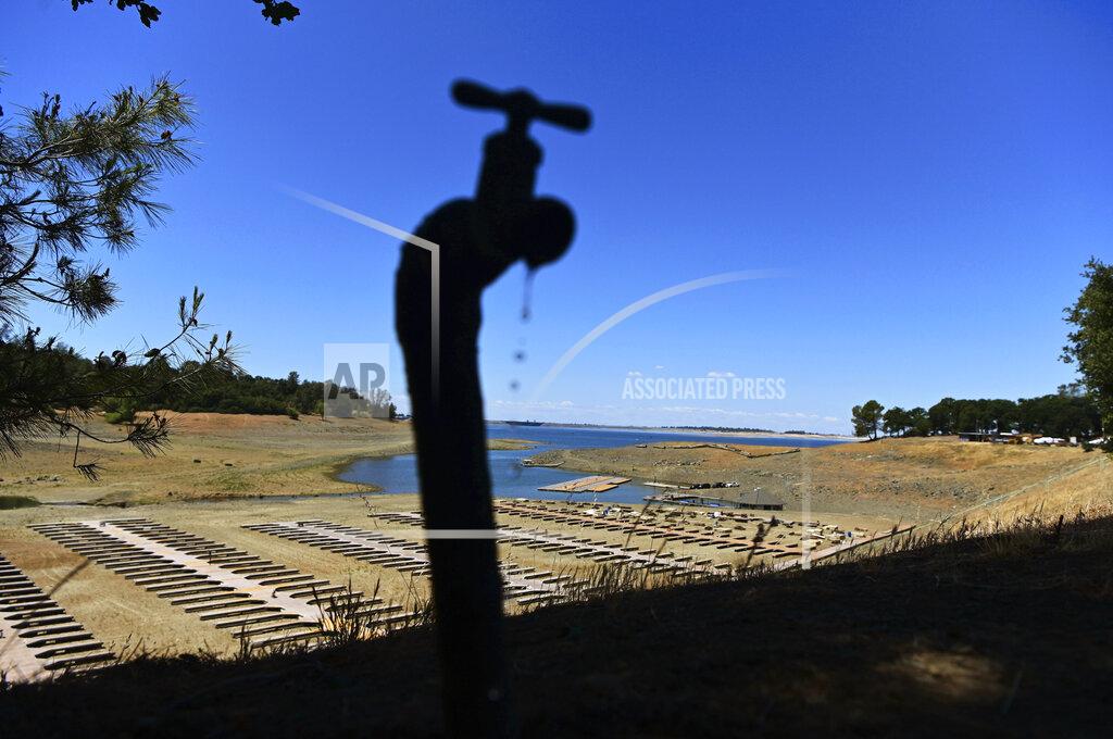 Josh Edelson FILE - Water drips from a faucet near boat docks sitting on dry land at the Browns Ravine Cove area of drought-stricken Folsom Lake, in Folsom, Calif., on May 22, 2021. The sight of fountains, swimming pools, gardens and golf courses in Western cities like Phoenix, Los Angeles, Las Vegas, San Diego and Albuquerque can seem jarring with drought and climate change tightening their grip on the region. But Western water experts say they aren’t necessarily cause for concern. Many Western cities over the past three decades have diversified their water sources, boosted local supplies, and use water more efficiently now than in the past.(AP Photo/Josh Edelson, File)