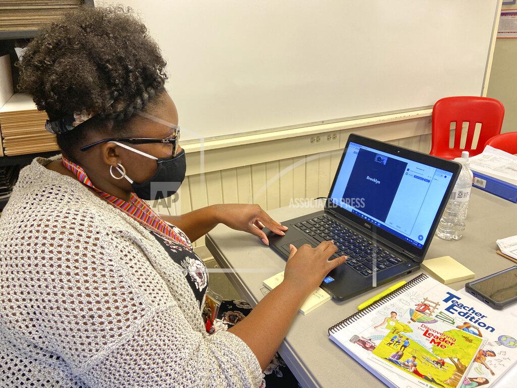 Bill Graham Fifth grade math teacher Jymeka Johnson logs into a Zoom session at Poplar Springs Elementary School in Meridian, Miss., Monday, Aug. 10, 2020. Schools are reopening this week under new guidelines after being closed in March as the COVID-19 pandemic spread. Meridian Public School District students are starting the year using online learning, with plans to return to campus in September. (Bill Graham/The Meridian Star via AP)