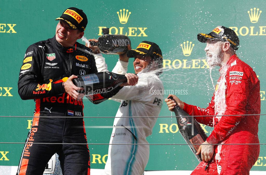 Laszlo Balogh Mercedes driver Lewis Hamilton, center, of Britain, winner of the Hungarian Formula One Grand Prix, celebrates on the podium with second placed Red Bull driver Max Verstappen, left, of the Netherlands, and third placed Ferrari driver Sebastian Vettel, of Germany, at the Hungaroring racetrack in Mogyorod, northeast of Budapest, Hungary, Sunday, Aug. 4, 2019. (AP Photo/Laszlo Balogh)