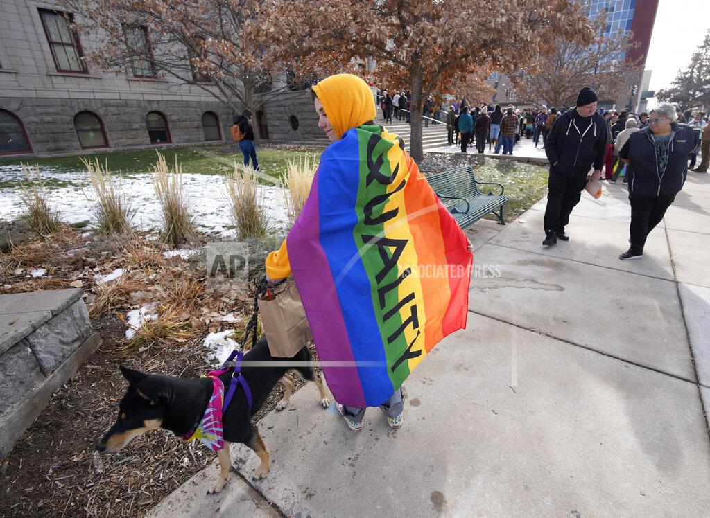 David Zalubowski Amy Kingsley of Salida, Colo., checks on her dog, Avalon, after they watched as a 25-foot historic pride flag was unfurled from the roof of City Hall to honor the victim's of the weekend mass shooting at a gay nightclub Wednesday, Nov. 23, 2022, in Colorado Springs, Colo. The flag, known as Section 93 of the Sea to Sea Flag, is on loan for two weeks to Colorado Springs from the Sacred Cloth Project. (AP Photo/David Zalubowski)
