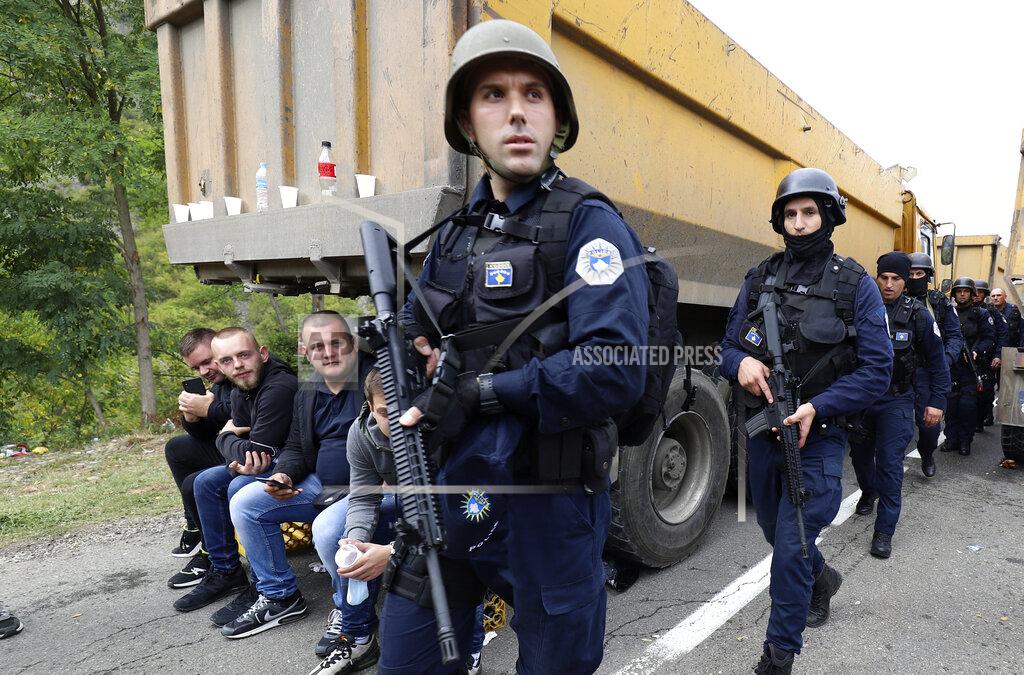 Bojan Slavkovic Kosovo police officers patrol by trucks where Kosovo Serbs block a road near the northern Kosovo border crossing of Jarinje, Monday, Sept. 20, 2021. Tensions soared Monday at the border between Kosovo and Serbia as Kosovo deployed additional police to implement a rule to remove Serbian license plates from cars entering Kosovo, while Serbs protested the move. (AP Photo/Bojan Slavkovic)