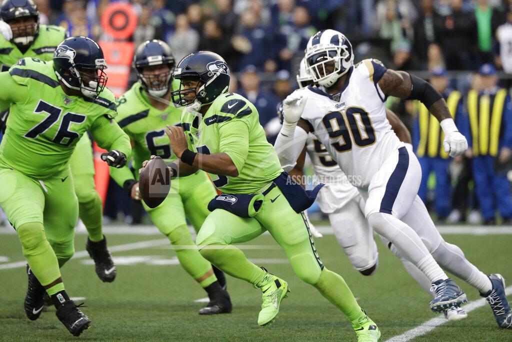 Elaine Thompson Seattle Seahawks quarterback Russell Wilson, center, scrambles away from Los Angeles Rams defensive end Michael Brockers (90) during the first half of an NFL football game Thursday, Oct. 3, 2019, in Seattle. (AP Photo/Elaine Thompson)