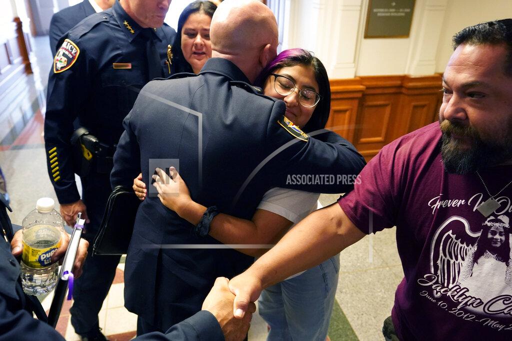 Eric Gay Jazmin Cazares, center, whose young sister Jacklyn was was one of 19 children killed by a gunman at Robb Elementary School, is hugged by Fort Worth Police Chief Neil Noakes as she and her parents, Javier, right, and mother, Gloria, rear, visit with a group of police chiefs after a hearing at the state capitol, Thursday, June 23, 2022, in Austin, Texas. (AP Photo/Eric Gay)