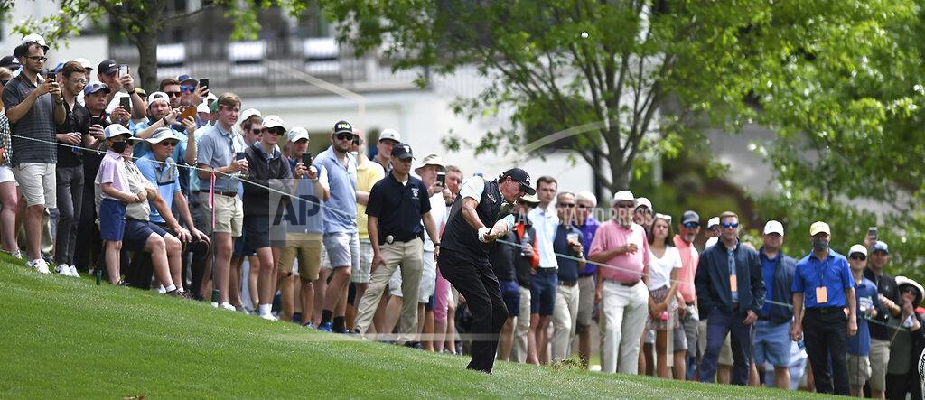 Jeff Siner Phil Mickelson hits a shot from a hill near the 15th green during the second round of the Wells Fargo Championship golf tournament at Quail Hollow Club in Charlotte, N.C., Friday, May 7, 2021. (Jeff Siner/The Charlotte Observer via AP)
