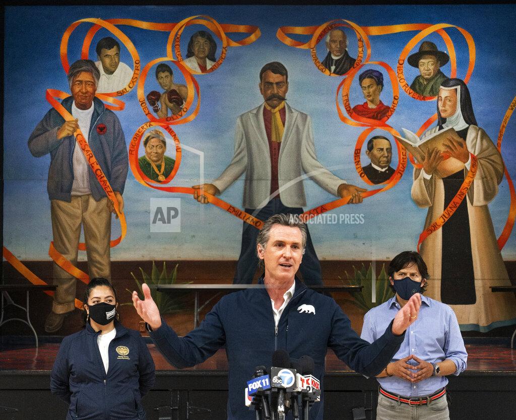 Damian Dovarganes FILE - In this Feb. 21, 2021, file photo, California Gov. Gavin Newsom, center, with Assemblywoman Wendy Carrillo, District 51, left, and Los Angeles City Council member Kevin de Leon, right, visit the Ramona Gardens Recreation Center in Los Angeles to discuss the state's efforts to vaccinate hard-to-reach and disproportionately impacted communities in Los Angeles. Latino voters who have been hard hit by the pandemic could be a key group of voters in Newsom's potential recall election. (AP Photo/Damian Dovarganes, File)