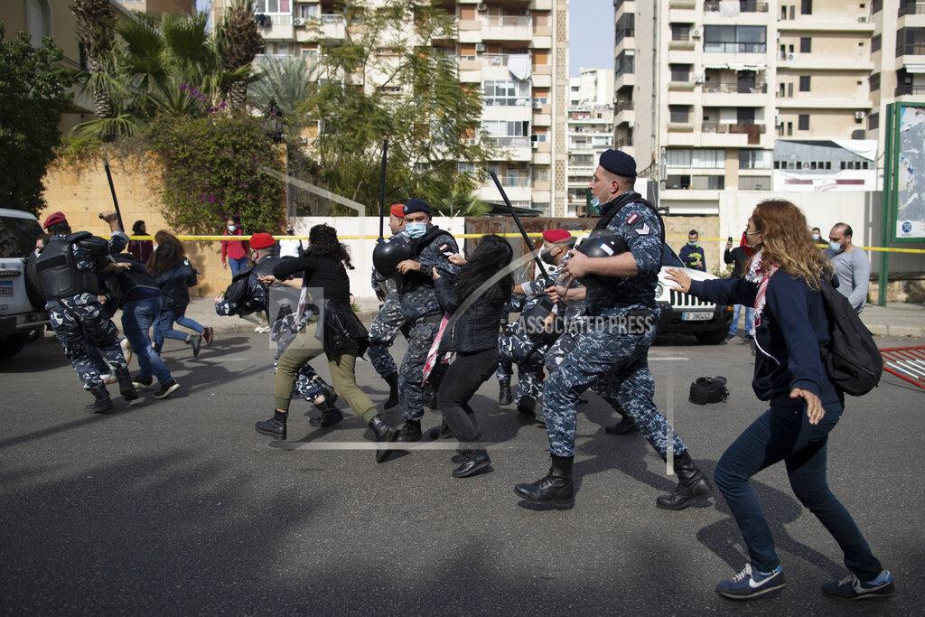 Hassan Ammar Riot police and army soldiers scuffle with anti-government protesters outside a military court in Beirut, Lebanon, Monday, Feb. 8, 2021. Riot police briefly clashed Monday in Beirut with hundreds of protesters demanding the release of anti-government activists detained following riots in northern Lebanon late last month. (AP Photo/Hassan Ammar)