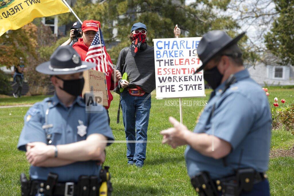 Michael Dwyer People demonstrate against state restrictions imposed over concern about COVID-19 near the residence of Gov. Charlie Baker, Saturday, May 16, 2020, in Swampscott, Mass. (AP Photo/Michael Dwyer)