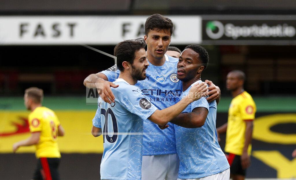 Adrian Dennis Manchester City's Raheem Sterling, right, celebrates with teammates after scoring his side's opening goal during the English Premier League soccer match between Watford and Manchester City at the Vicarage Road Stadium in Watford, England, Tuesday, July 21, 2020. (Adrian Dennis/Pool via AP)