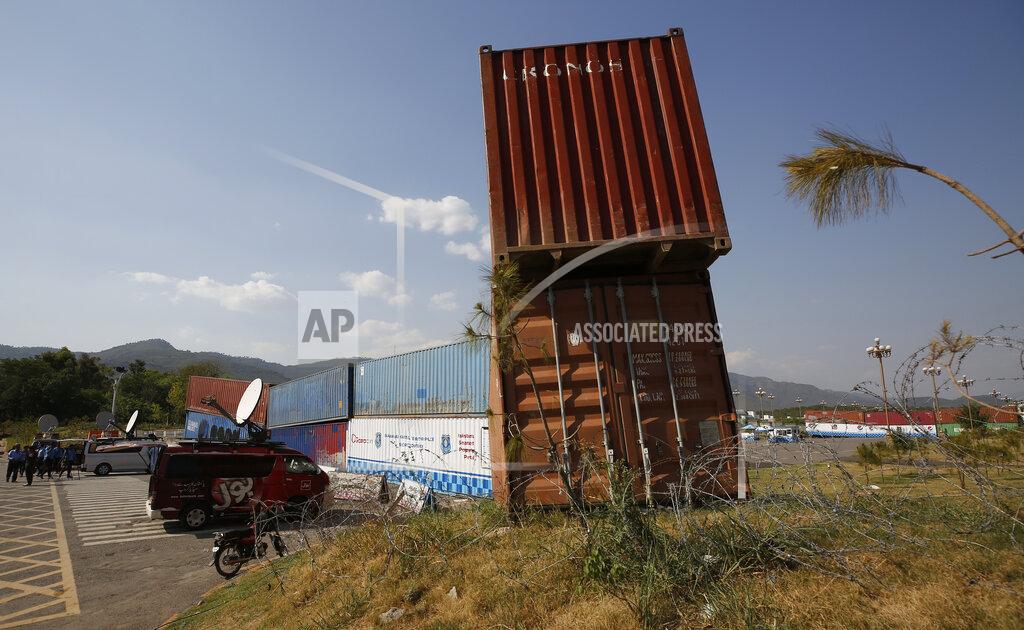 Anjum Naveed Police officers stand guard next to shipping containers placed by authorities to block a road leading to important government buildings in an attempt to foil a planned rally by Pakistan's key opposition party, in Islamabad, Pakistan, Tuesday, May 24, 2022. Pakistan banned ousted Prime Minister Imran Khan from holding a massive rally in the capital of Islamabad and cracked down on his supporters in overnight raids across the country, arresting hundreds. (AP Photo/Anjum Naveed)