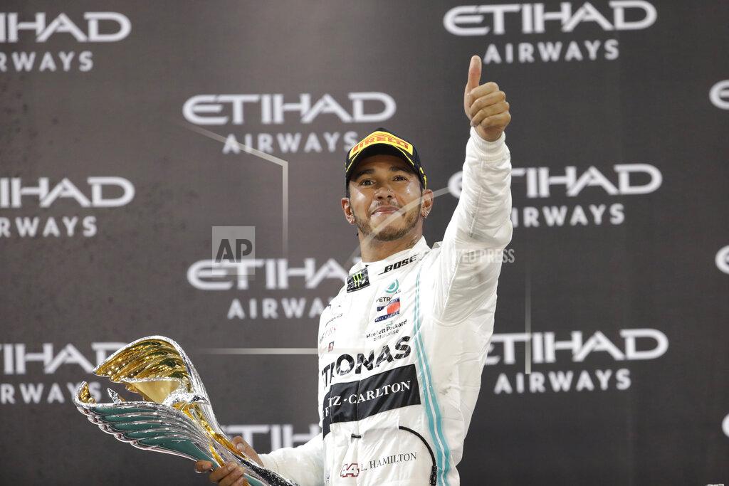 Luca Bruno Mercedes driver Lewis Hamilton of Britain celebrates on the podium after wining the Emirates Formula One Grand Prix, at the Yas Marina racetrack in Abu Dhabi, United Arab Emirates, Sunday, Dec.1, 2019. (AP Photo/Luca Bruno)