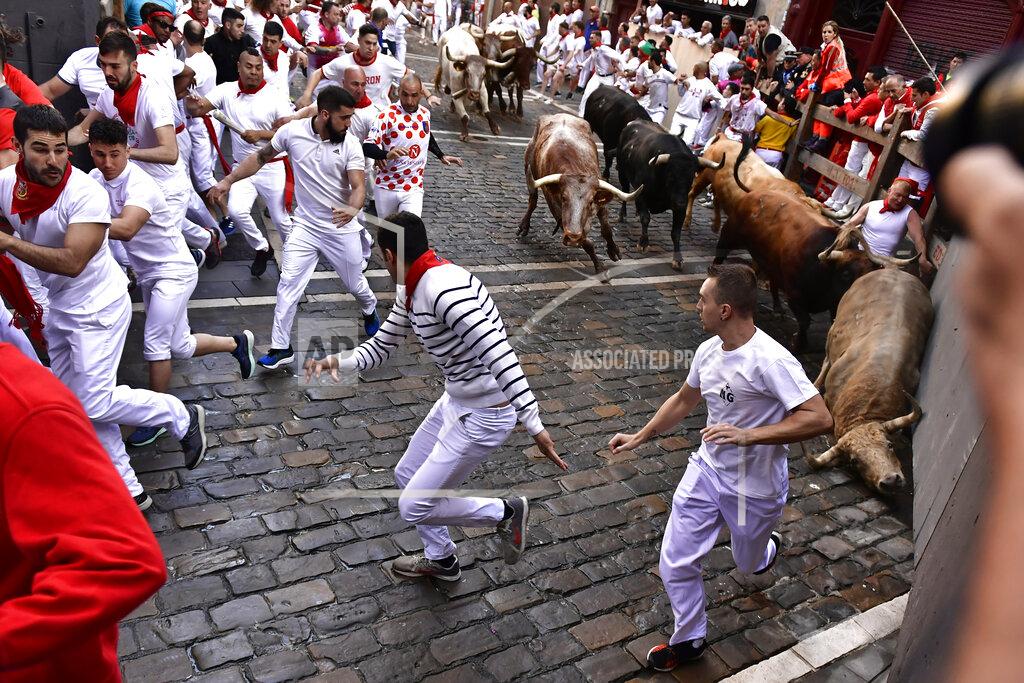 Alvaro Barrientos People run through the streets with fighting bulls and steers during the first day of the running of the bulls at the San Fermin Festival in Pamplona, northern Spain, Thursday, July 7, 2022. Revellers from around the world flock to Pamplona every year for nine days of uninterrupted partying in Pamplona's famed running of the bulls festival which was suspended for the past two years because of the coronavirus pandemic. (AP Photo/Alvaro Barrientos)